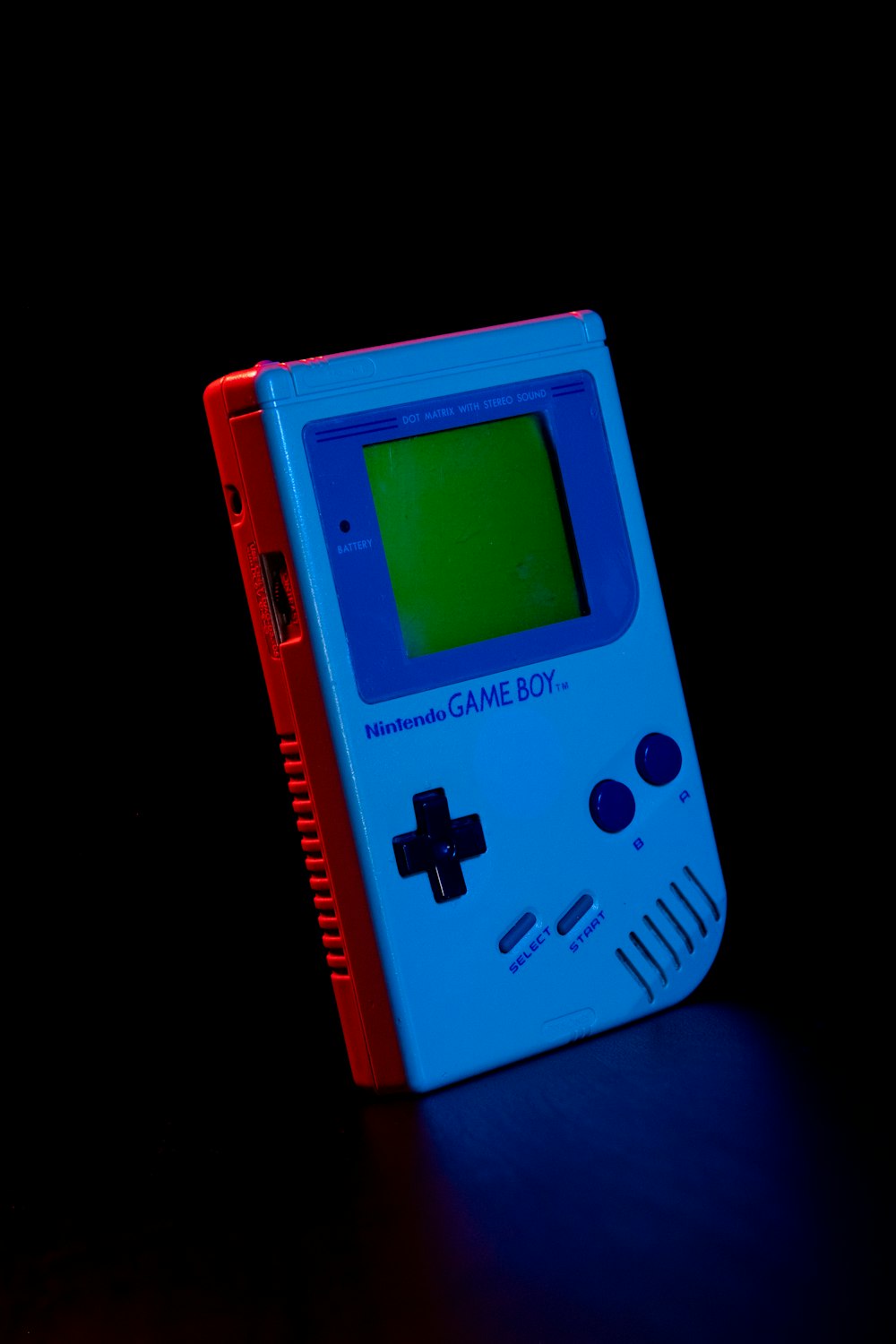 Ein blau-roter Gameboy sitzt auf einem Tisch