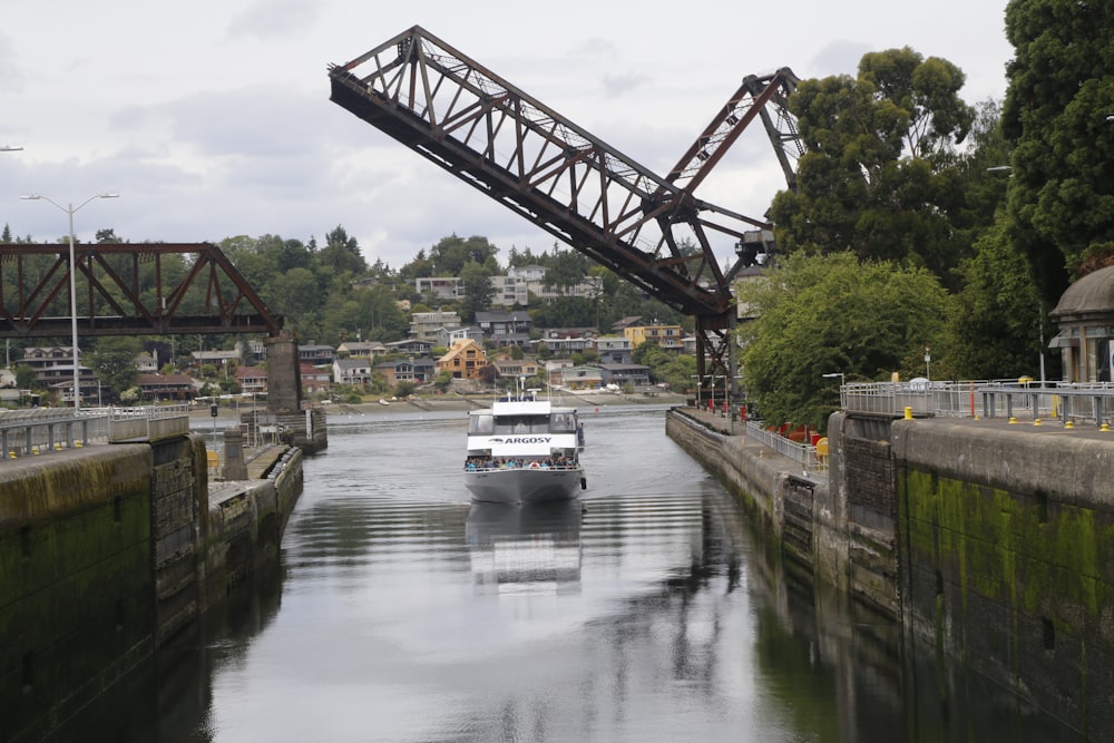 a boat traveling down a river under a bridge