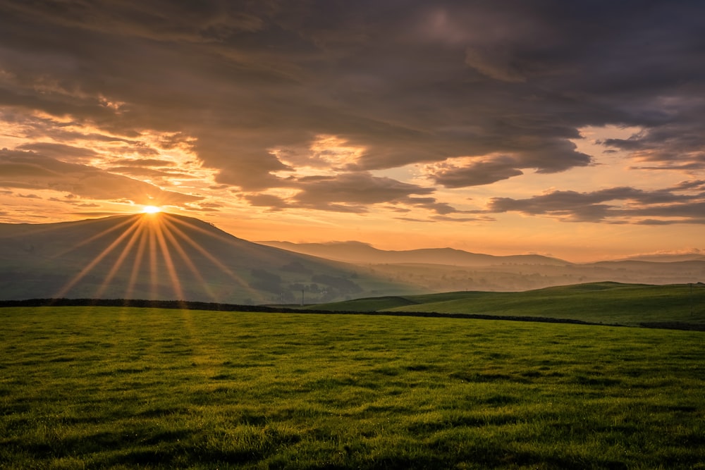 Il sole sta tramontando su un campo erboso