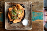 a plate of food on a table next to a glass of milk