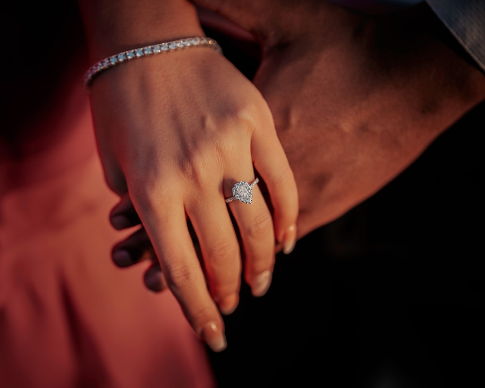 a close up of a person holding a diamond ring