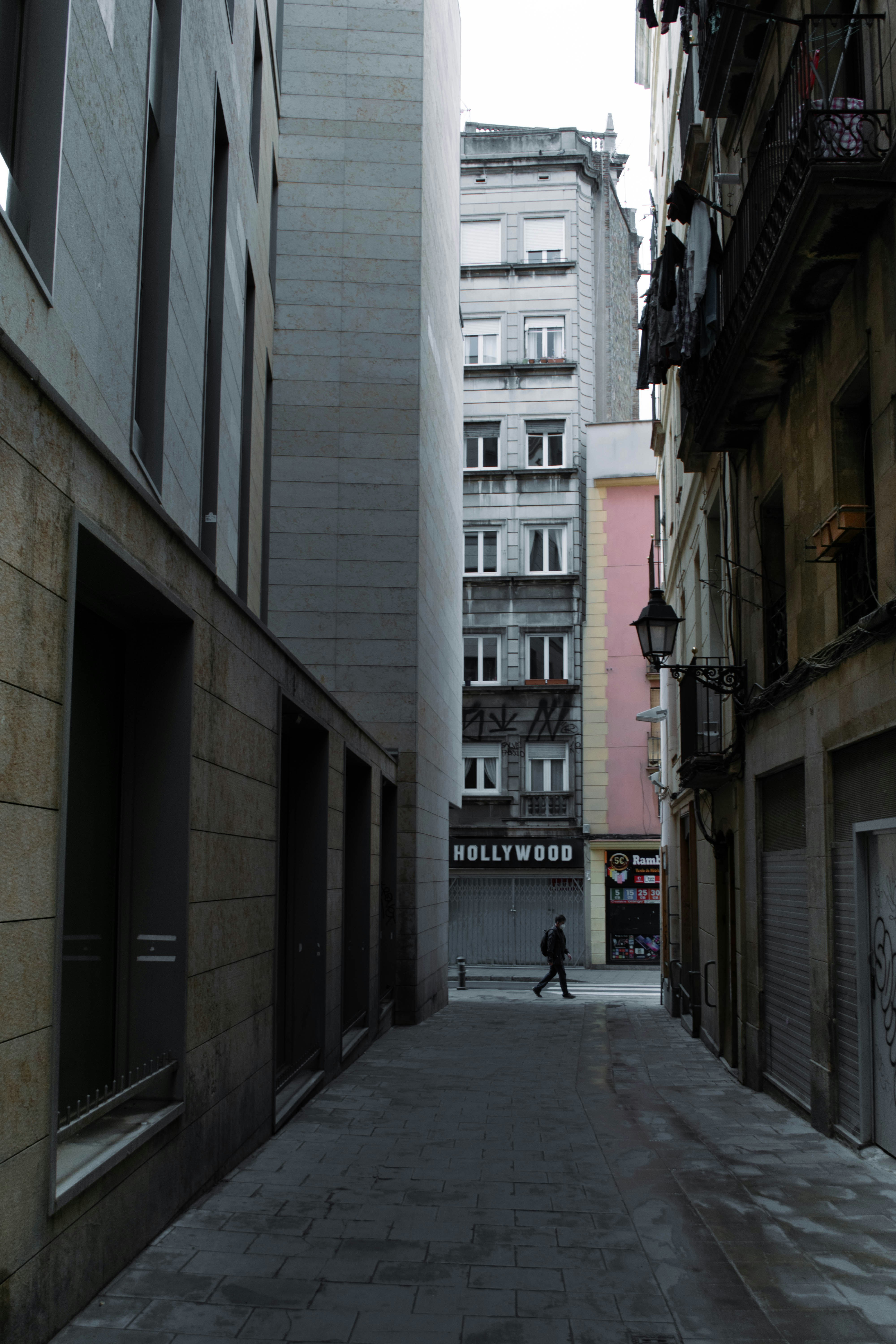 a man walking down a street next to tall buildings