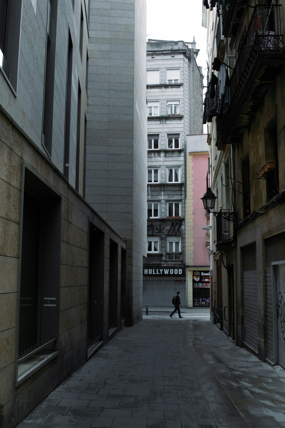 a man walking down a street next to tall buildings