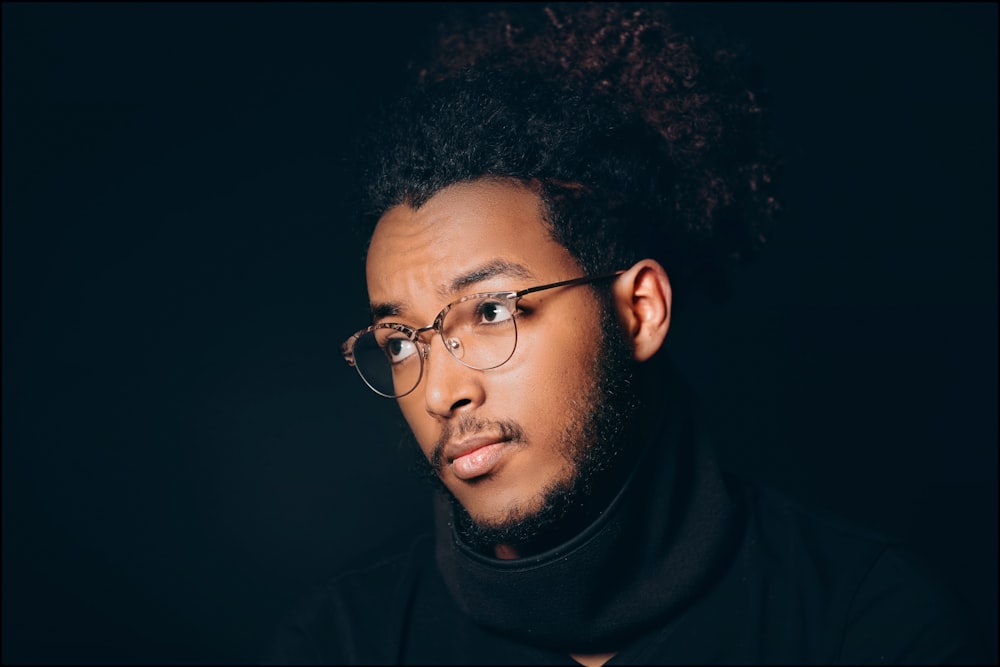 a man wearing glasses and a turtle neck sweater