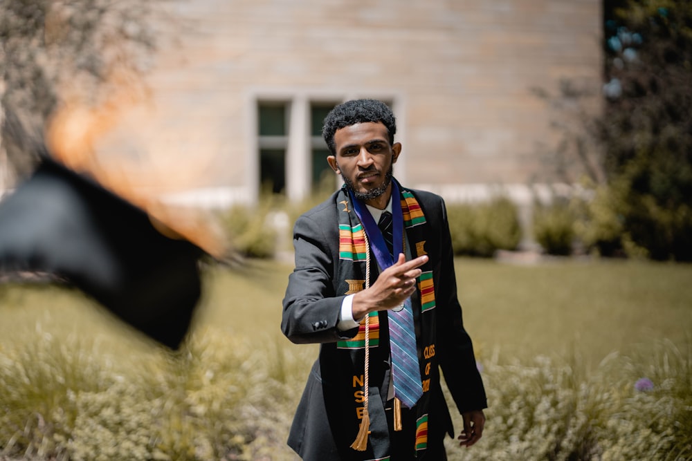 a man in a suit and tie holding a black umbrella