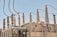An array of electrical insulators and conductors on top of a large power transformer. The insulators have a cylindrical, ribbed design to prevent electrical leaks, and there are several wires and cables connected to them. Cooling fans are visible on the side of the transformer.