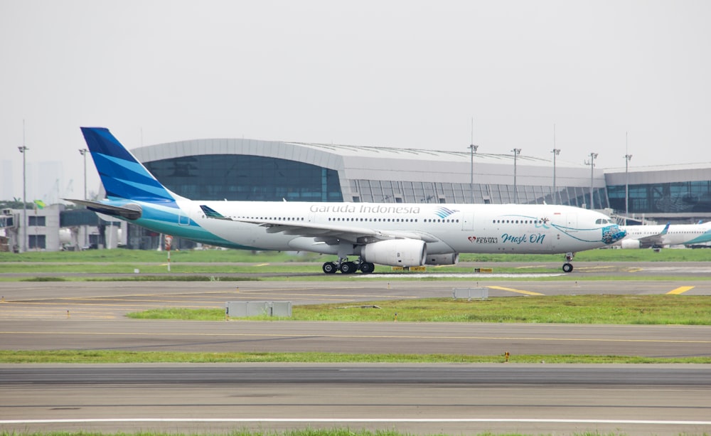 un gros avion de ligne assis au sommet d’une piste d’aéroport