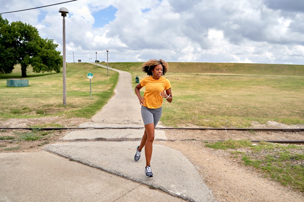 a woman running down a path in a park