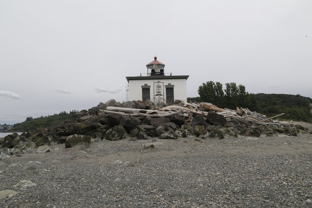 a lighthouse on a rocky shore with trees in the background