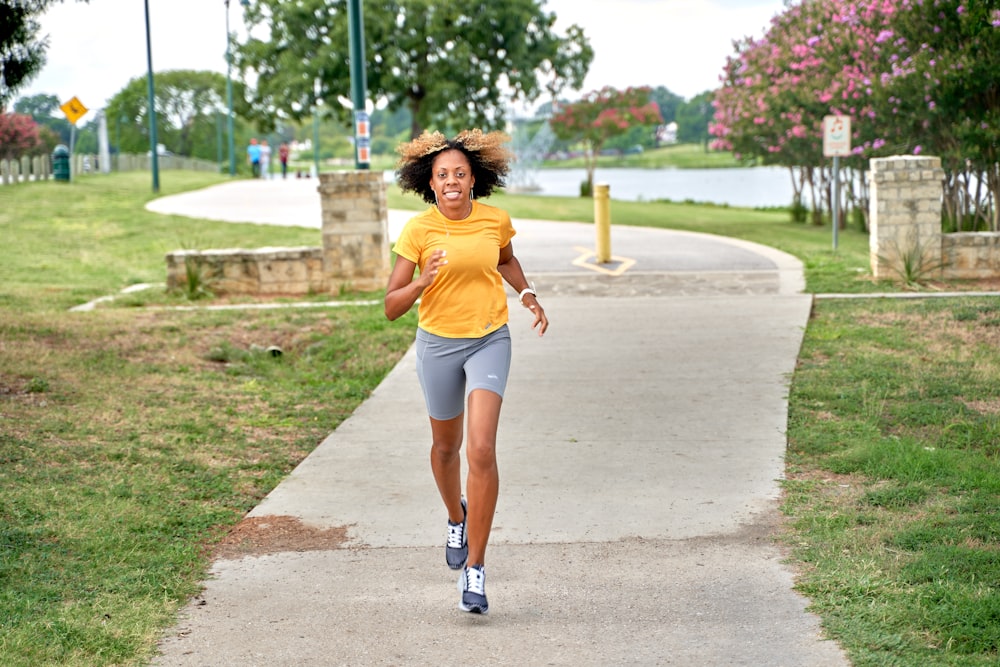Una mujer corriendo por una acera en un parque