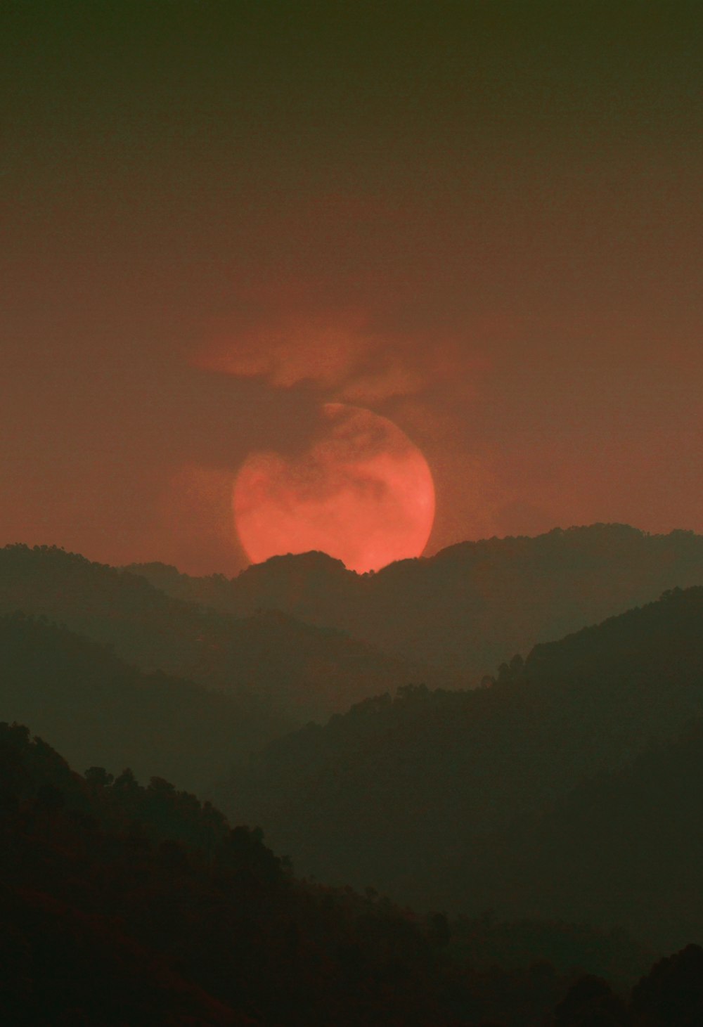 the sun is setting over a mountain range