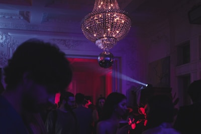 a group of people in a room with a chandelier