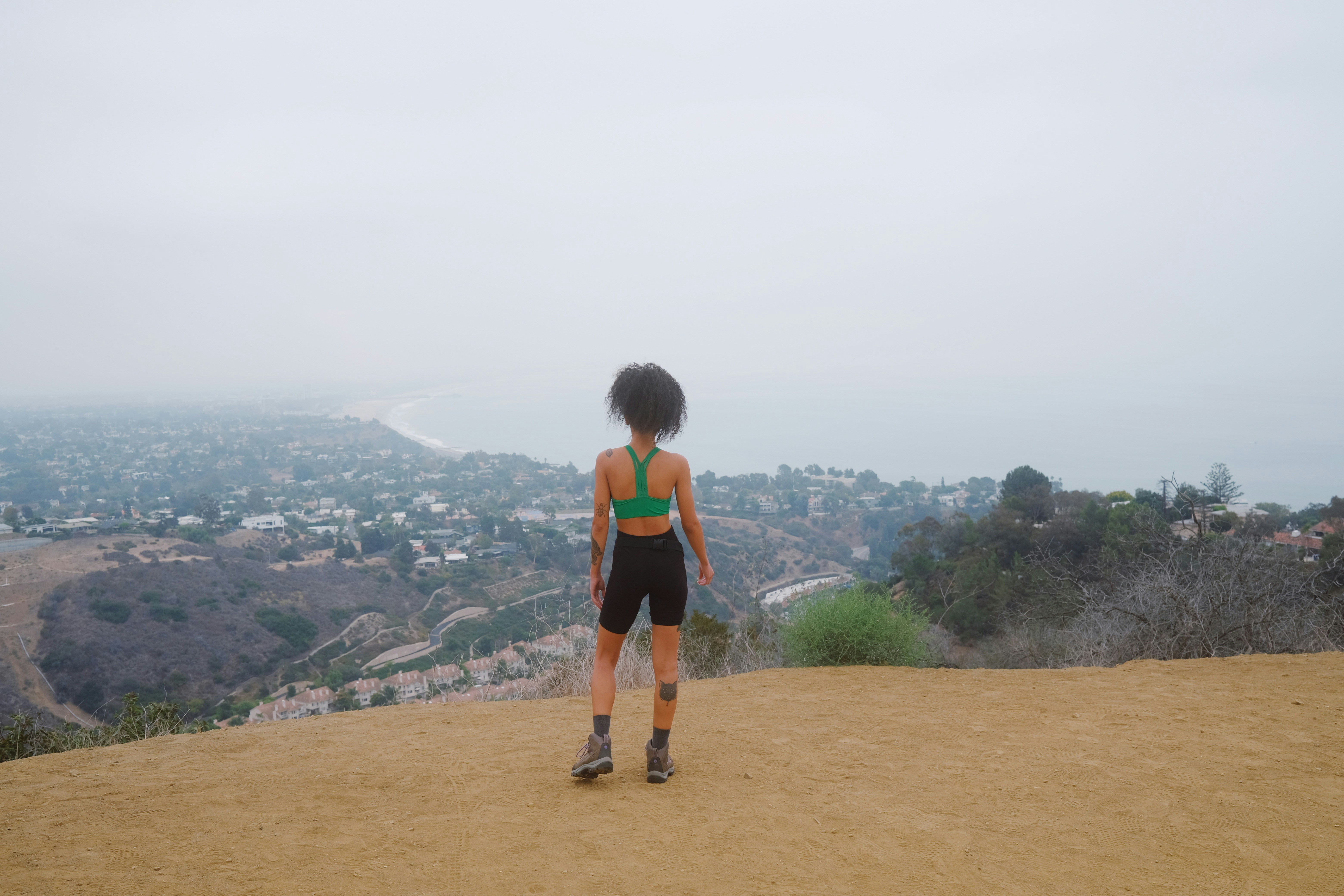 a woman standing on top of a dirt hill, 