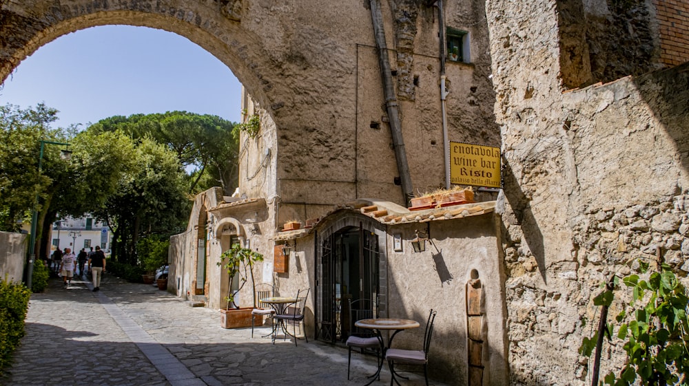 a cobblestone street with an archway leading to a restaurant