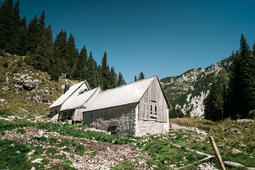an old barn sits in the middle of a mountain