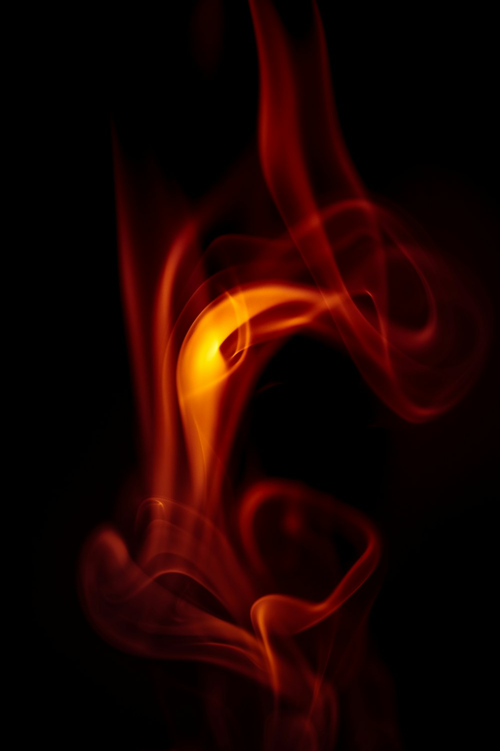 a red and yellow smoke swirls in the dark