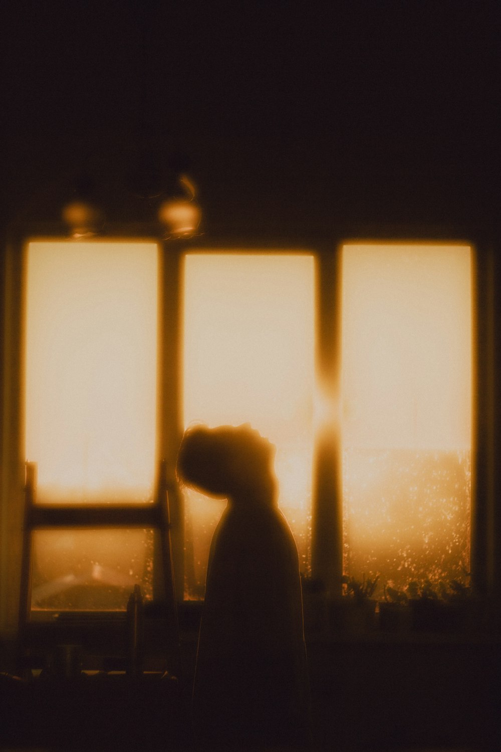 a silhouette of a person standing in front of a window