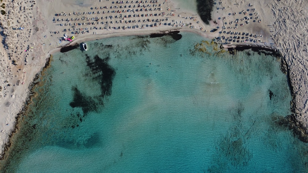an aerial view of a sandy beach with blue water