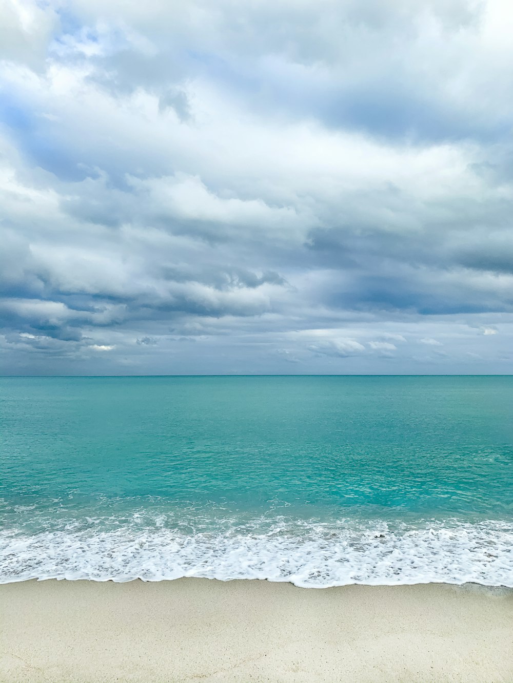 a view of the ocean from a sandy beach