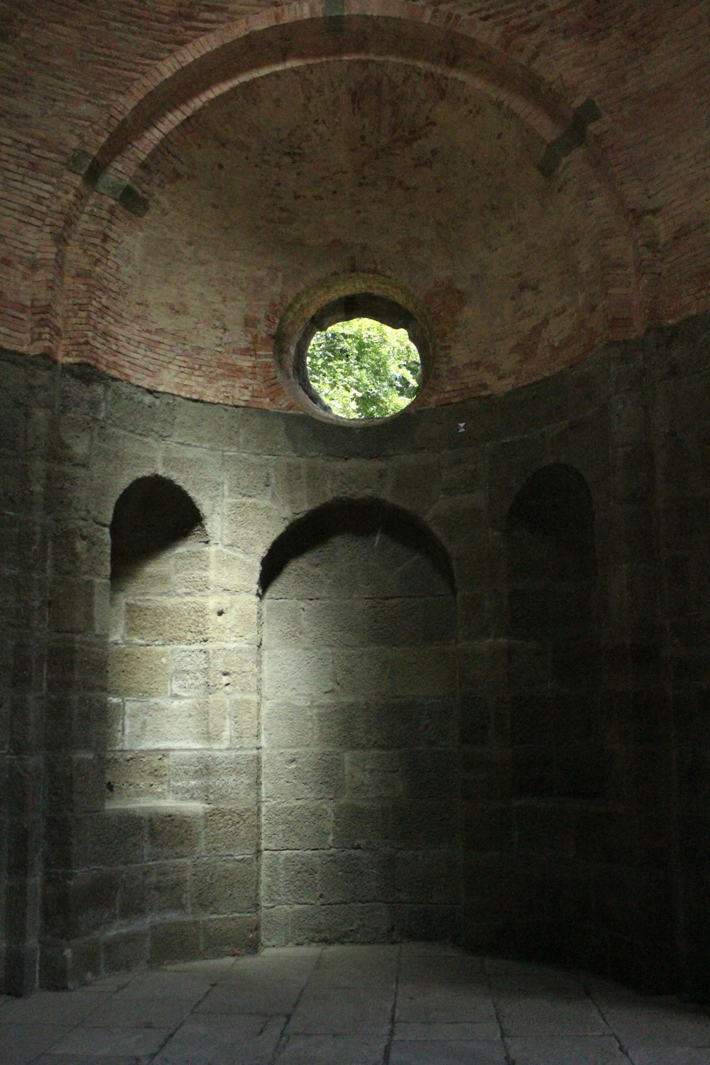 a stone room with a round window in it