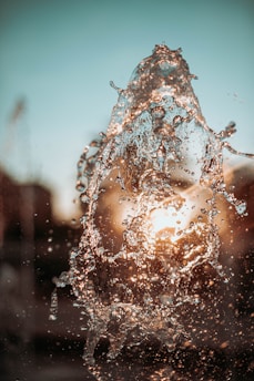 a close up of a water fountain with a blue sky in the background