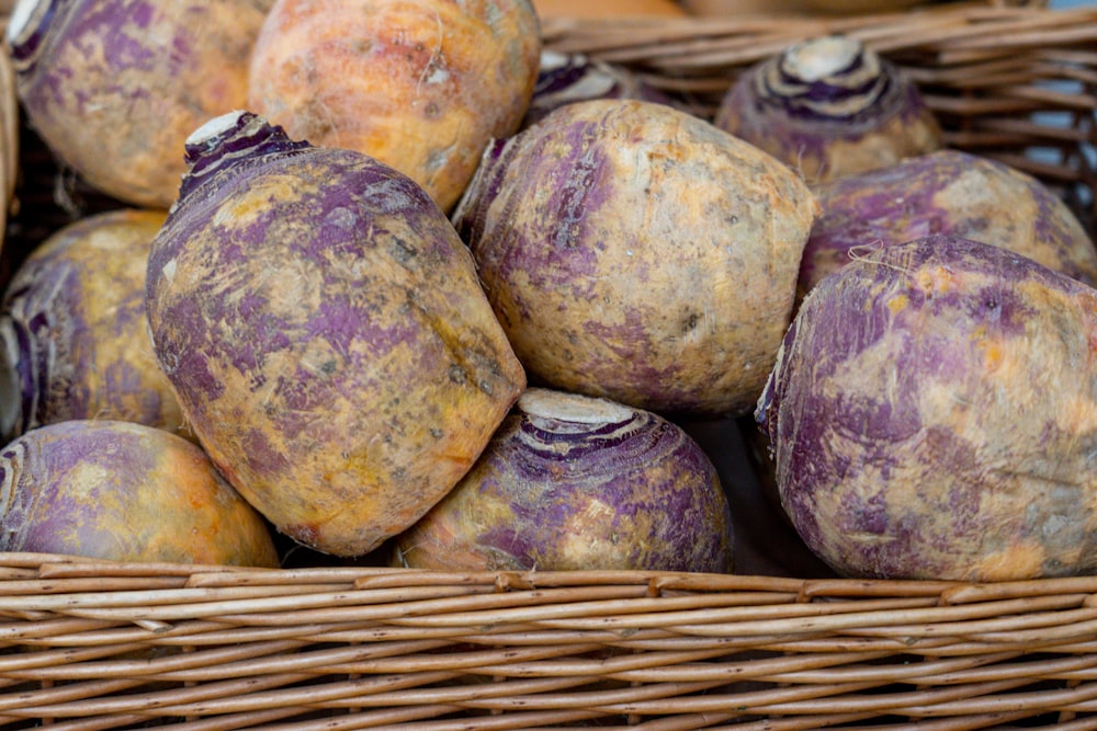 un panier rempli de pommes de terre violettes posé sur une table