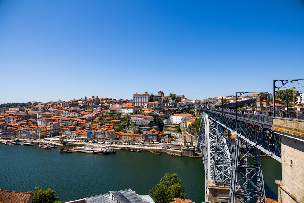 a bridge over a river with a city in the background