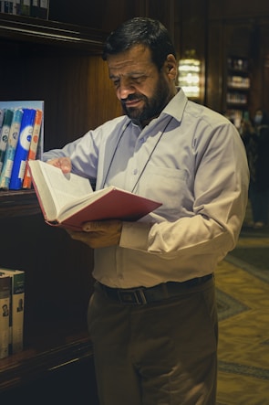 a man reading a book in a library