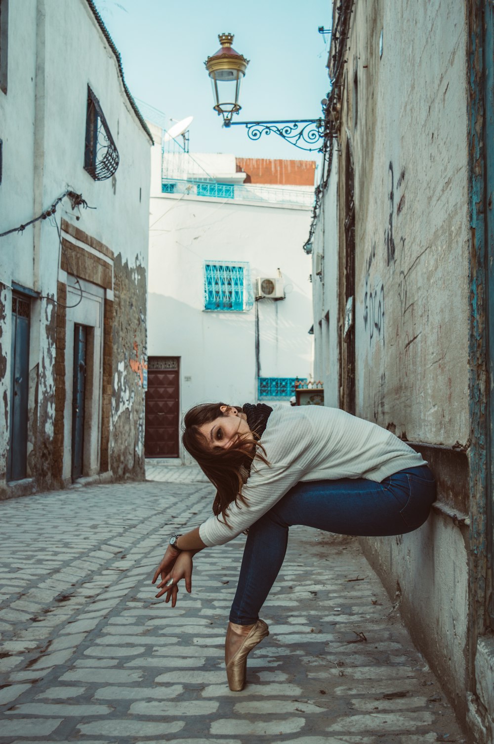 a woman leaning against a wall in a narrow alleyway