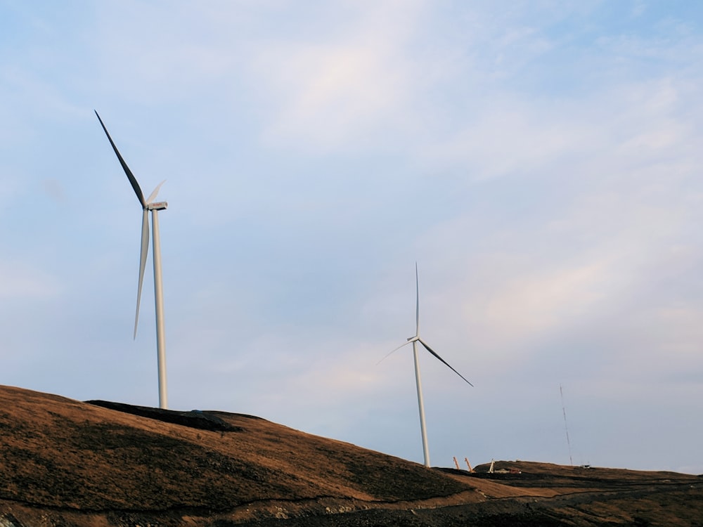 a group of wind turbines on top of a hill