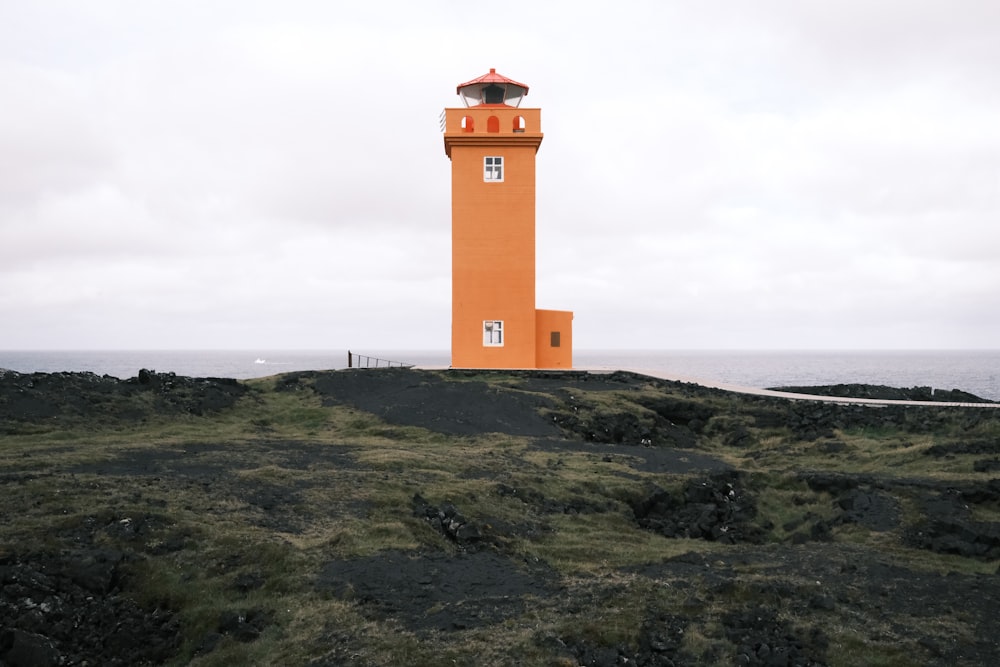 Un grande faro arancione sulla cima di una collina