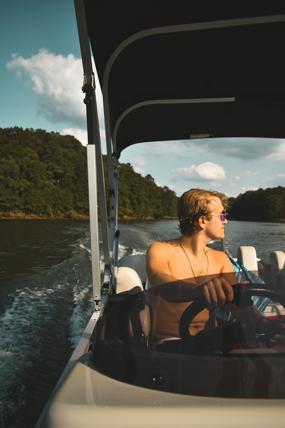 a man driving a boat on a body of water