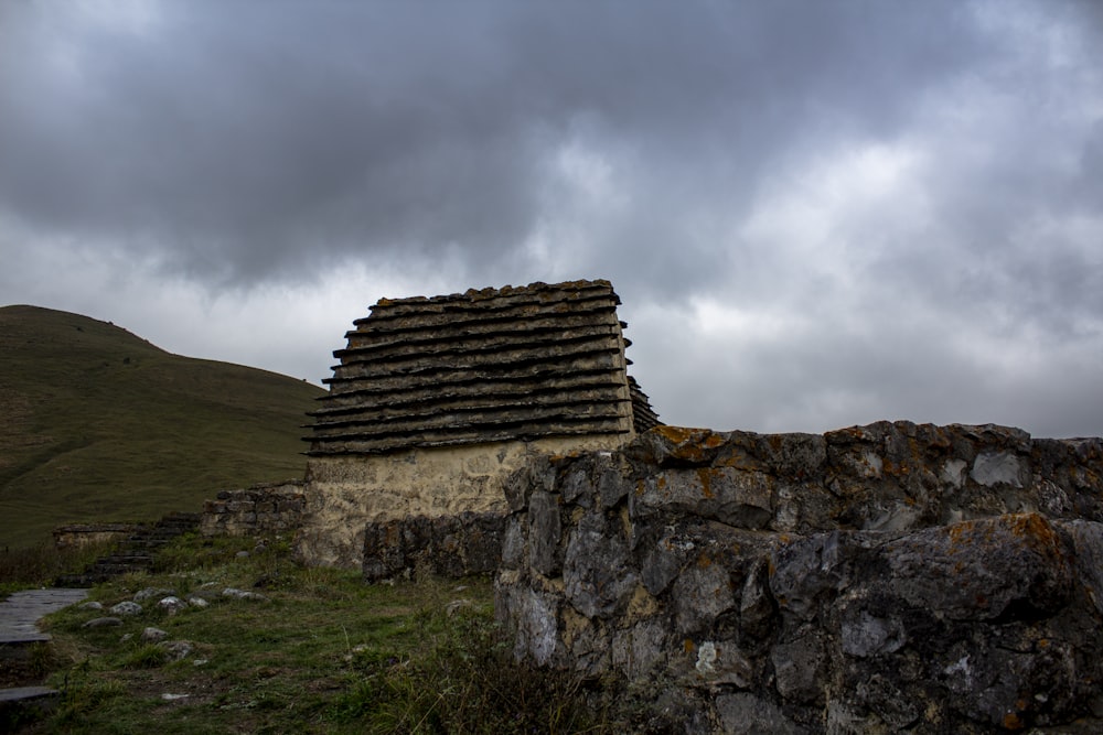a stone wall with a small building on top of it