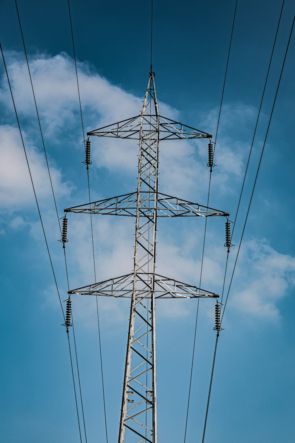 a high voltage power line against a blue sky