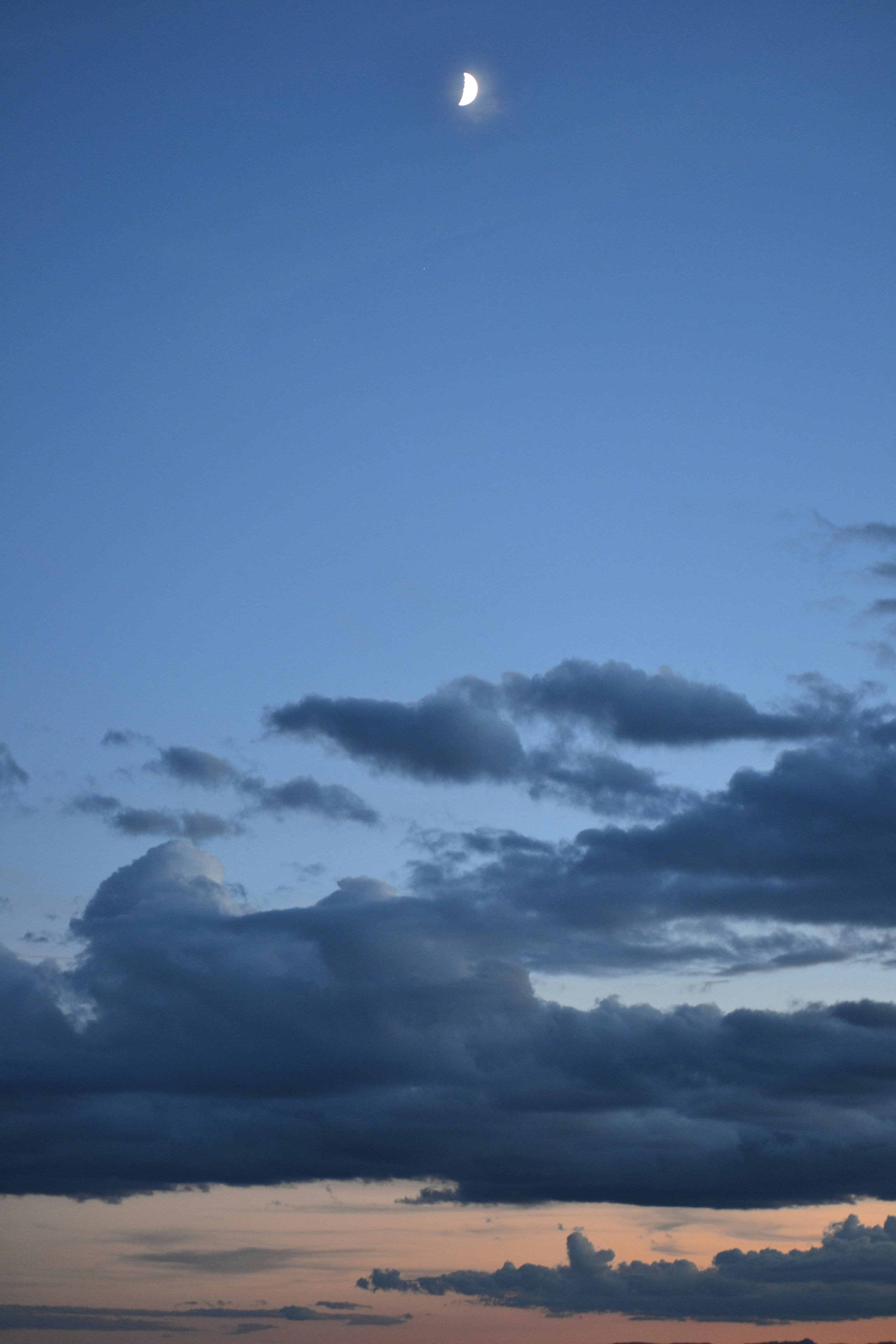 a full moon is seen in the sky above the ocean