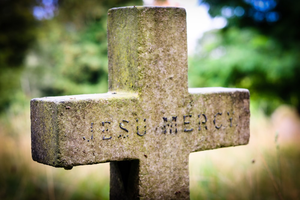Una croce di pietra con la parola Gesù scritta su di essa
