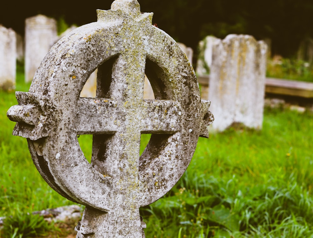 a close up of a stone cross in a cemetery