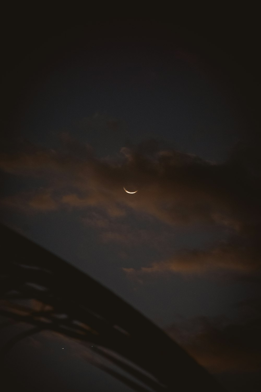 the moon is seen through the clouds in the night sky