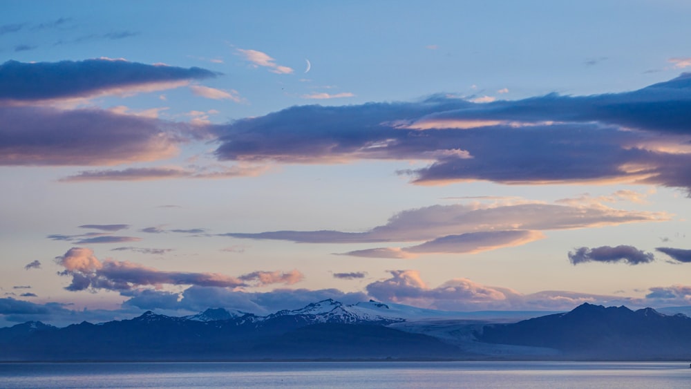 a large body of water with mountains in the background