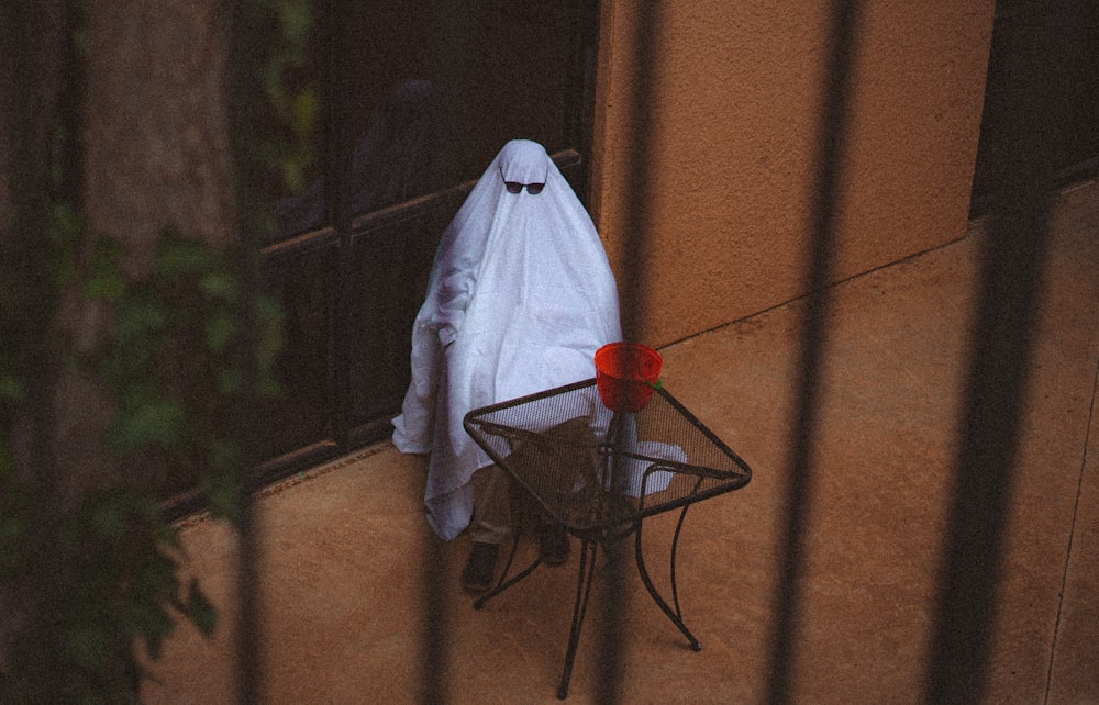 a ghost sitting on top of a chair next to a table