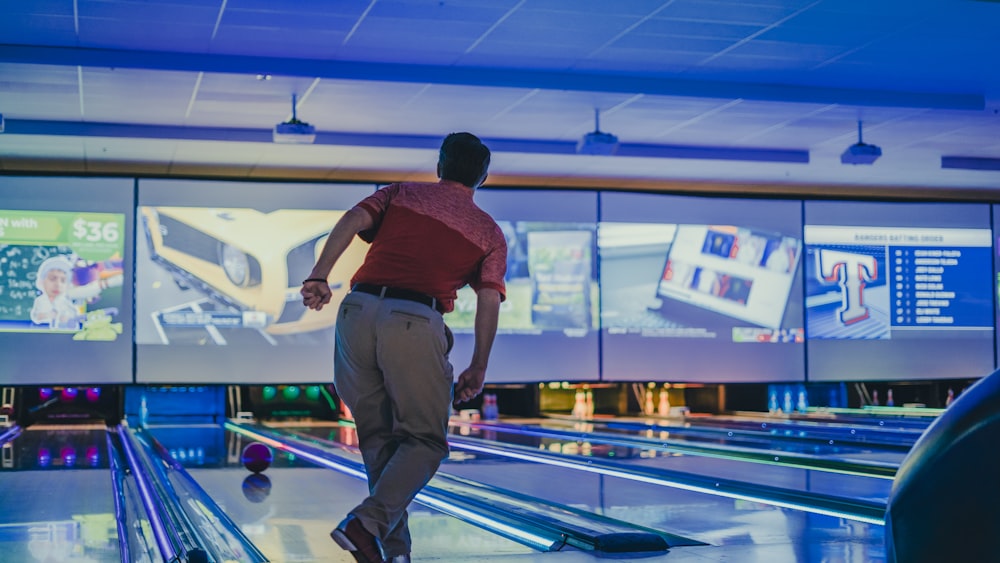 a man in a red shirt is bowling