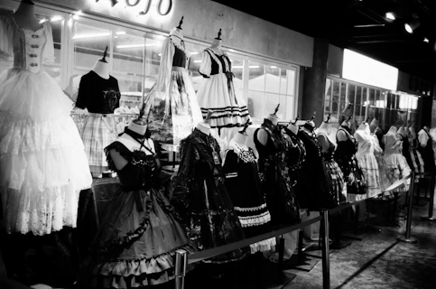 a black and white photo of dresses on display