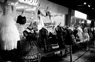 a black and white photo of dresses on display