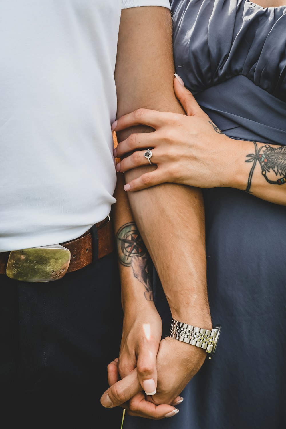 a couple holding hands while standing next to each other