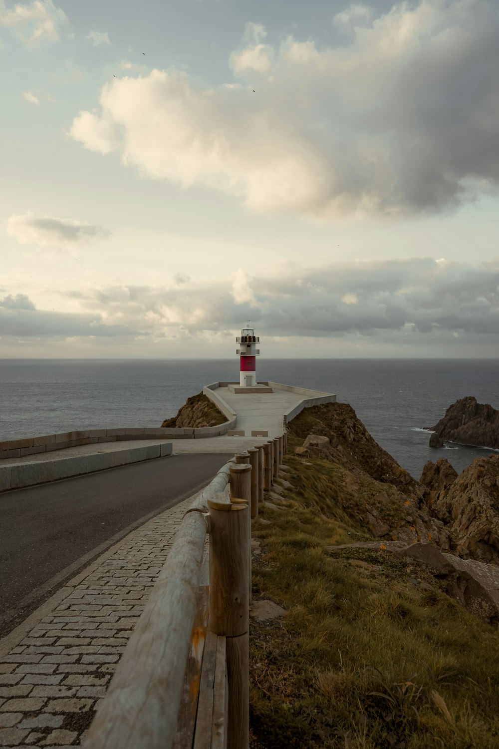 a lighthouse on the side of a road near the ocean