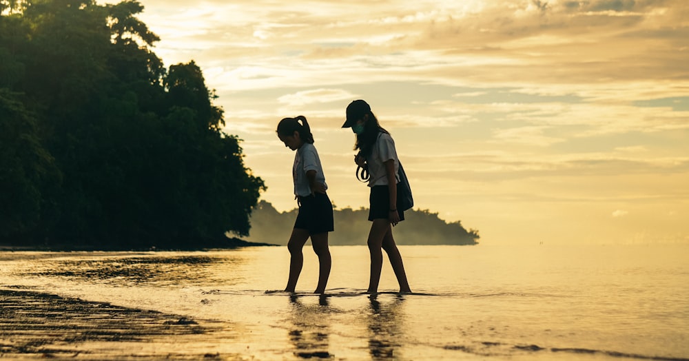 a couple of people that are standing in the water