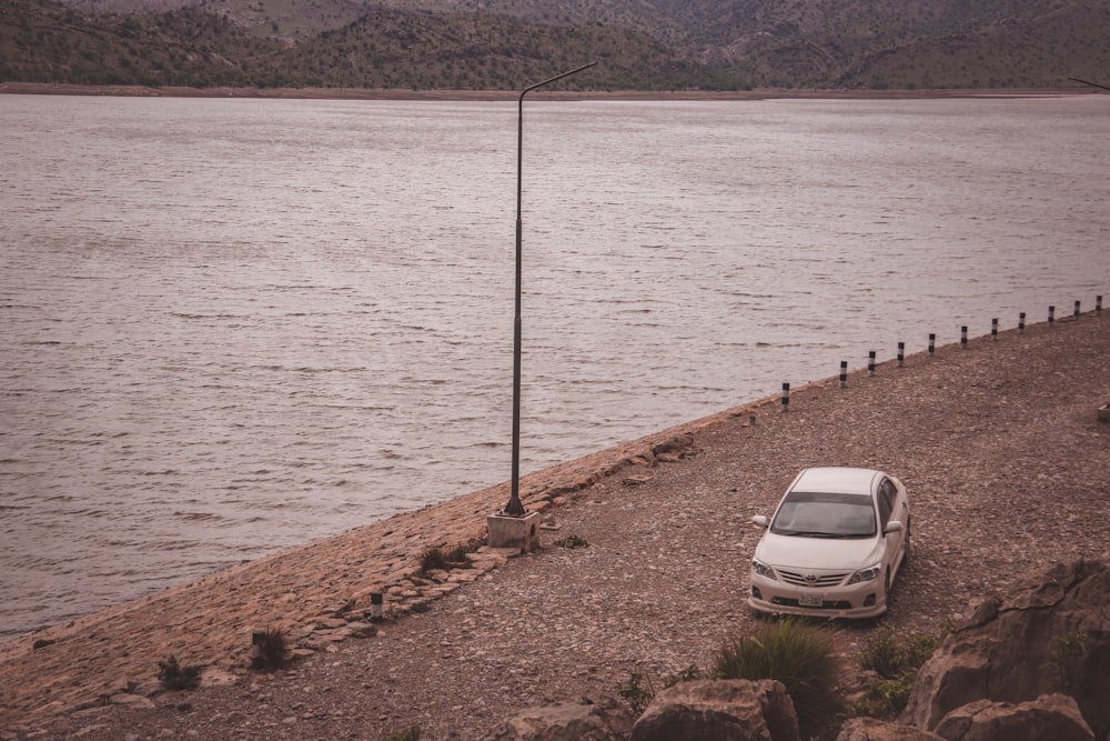 a car parked on the side of a body of water