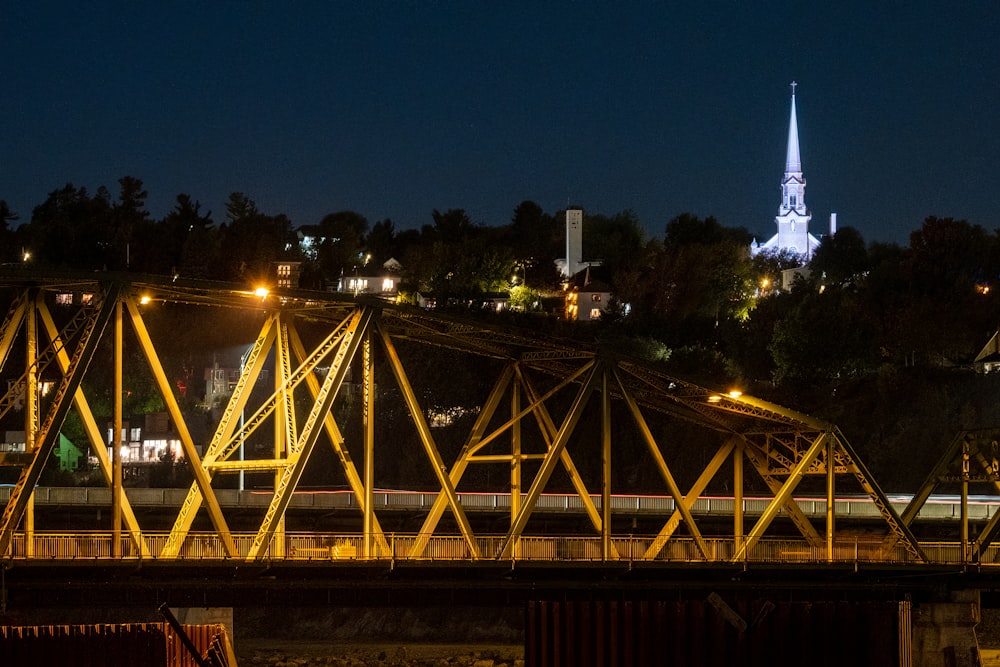 a train crossing a bridge lit up at night