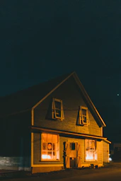 a yellow house with windows lit up at night