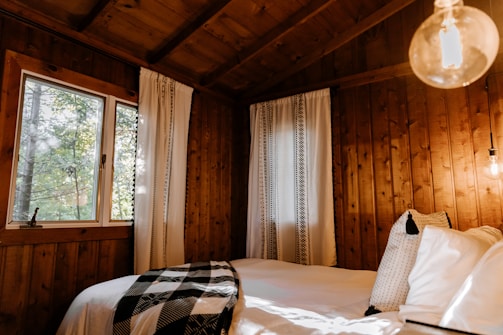 Cozy wooden cabin room with soft natural light filtering through linen curtains.